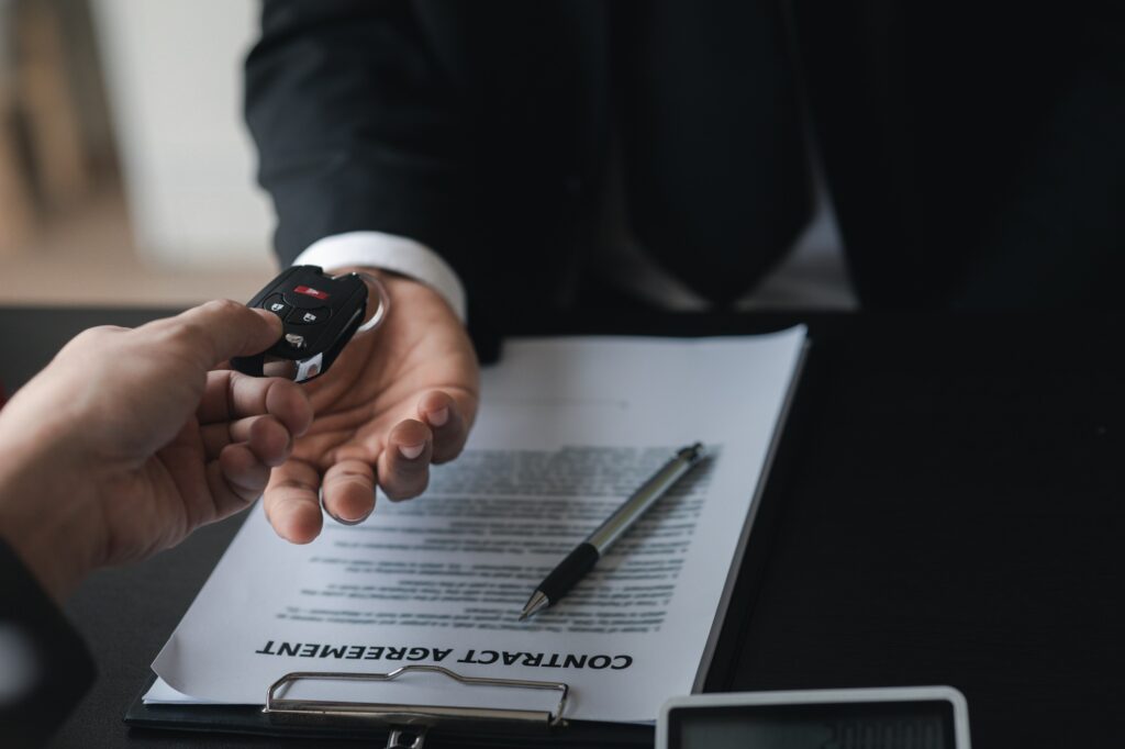 A car rental company employee pointed out the renter to sign the rental agreement after discussing t